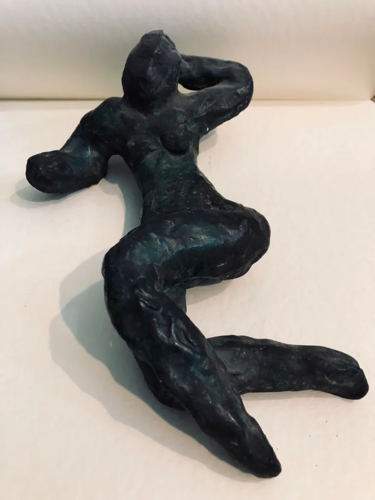 The green figure seen from her feet, the shoulders furthest from the camera.