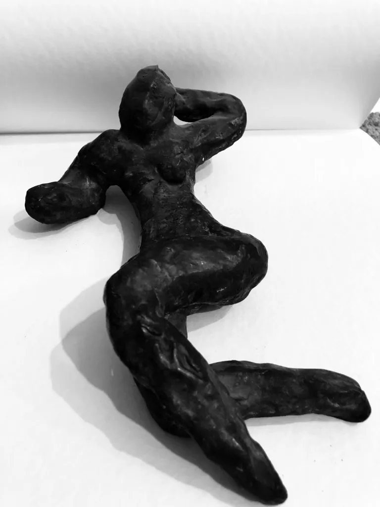 The reclining figure photographed in black and white, one arm behind the head.